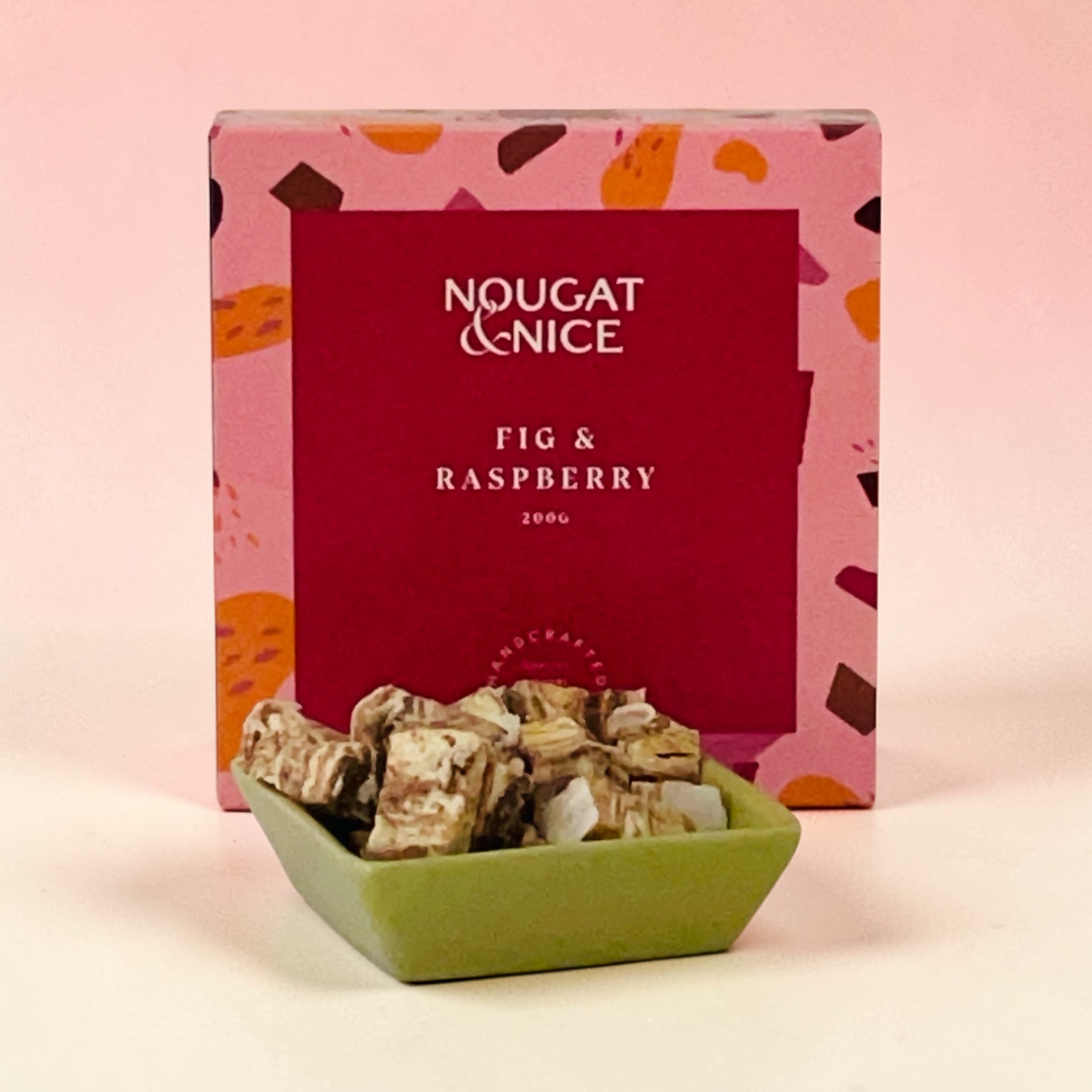 Box of Nougat & Nice Fig & Raspberry nougat on a pink background